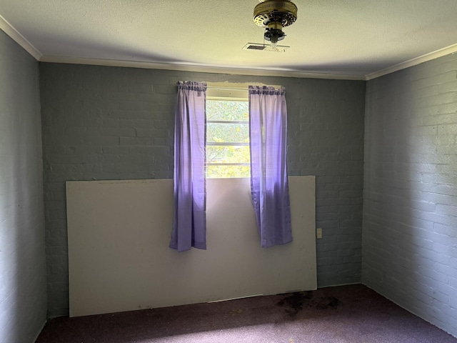 empty room featuring carpet floors, visible vents, and crown molding