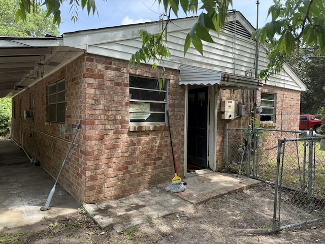exterior space featuring brick siding and fence