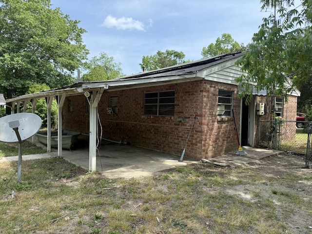 back of house with brick siding and fence