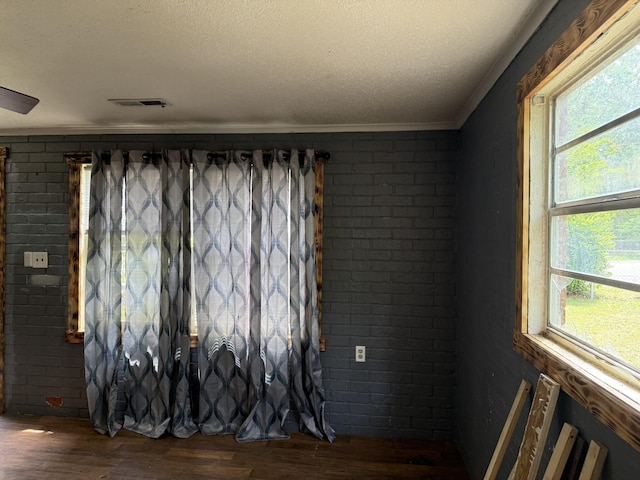 room details featuring crown molding, wood finished floors, a textured ceiling, and visible vents