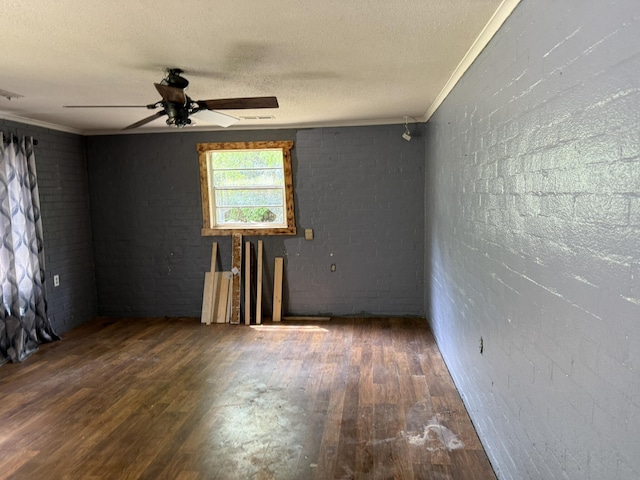 spare room featuring a ceiling fan, ornamental molding, wood finished floors, and a textured ceiling