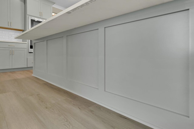 interior space with backsplash and light hardwood / wood-style floors