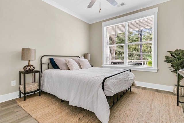 bedroom with ornamental molding, light wood-type flooring, and ceiling fan