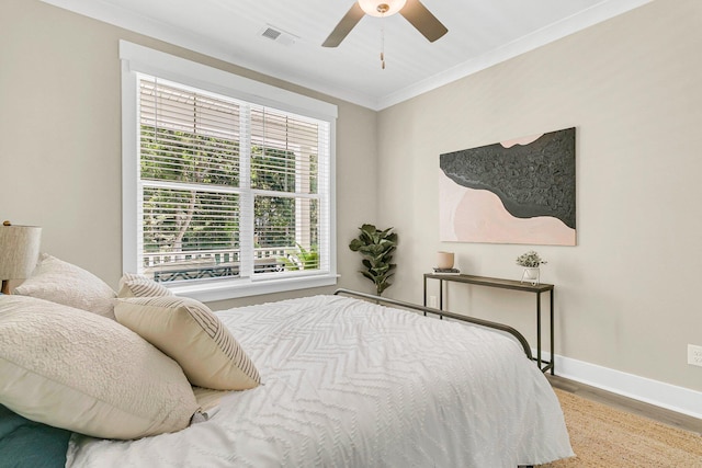 bedroom featuring ceiling fan, hardwood / wood-style flooring, and crown molding