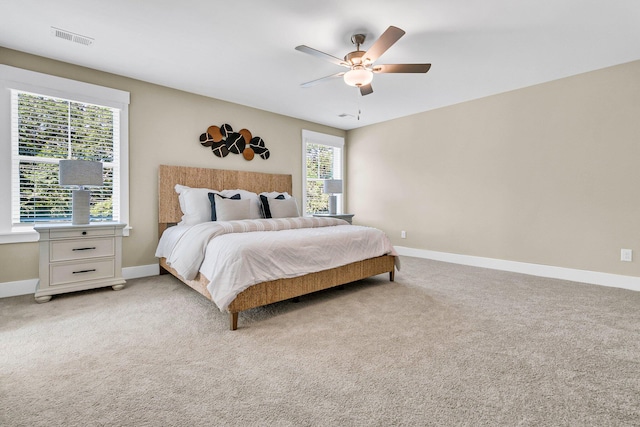 carpeted bedroom featuring ceiling fan and multiple windows