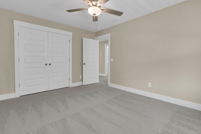 unfurnished bedroom with ceiling fan, a closet, and light carpet