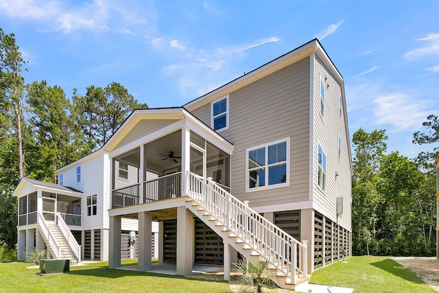 back of house with ceiling fan, a sunroom, and a yard