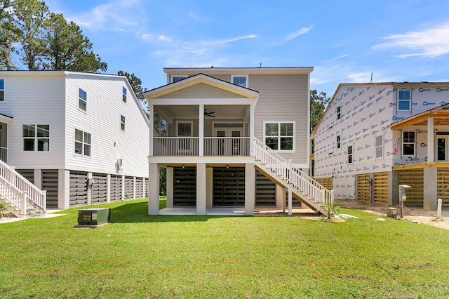 rear view of house with a lawn, cooling unit, and ceiling fan