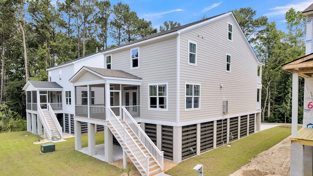 rear view of property featuring a lawn and a sunroom