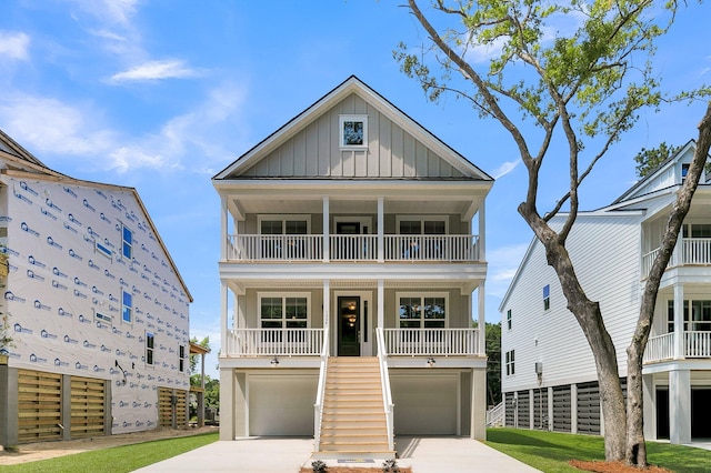 coastal inspired home featuring a balcony, a porch, and a garage