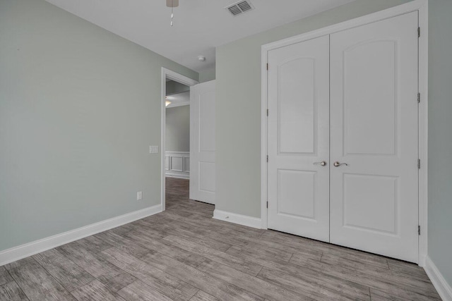 unfurnished bedroom with a closet and light hardwood / wood-style flooring