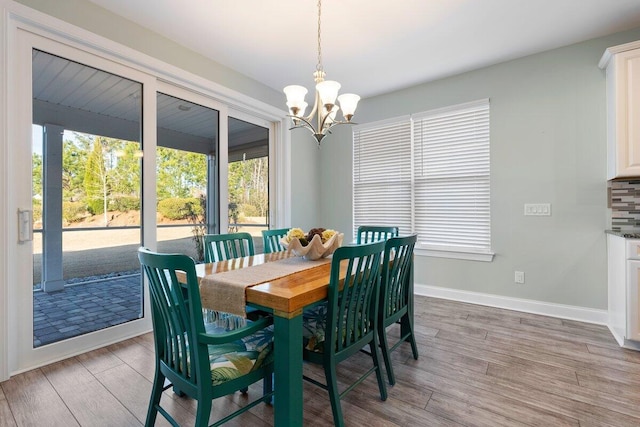 dining space with a notable chandelier, light hardwood / wood-style flooring, and plenty of natural light