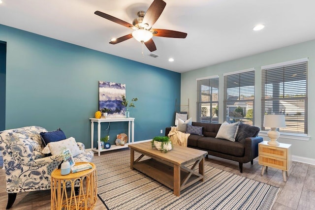 living room featuring ceiling fan and a wealth of natural light