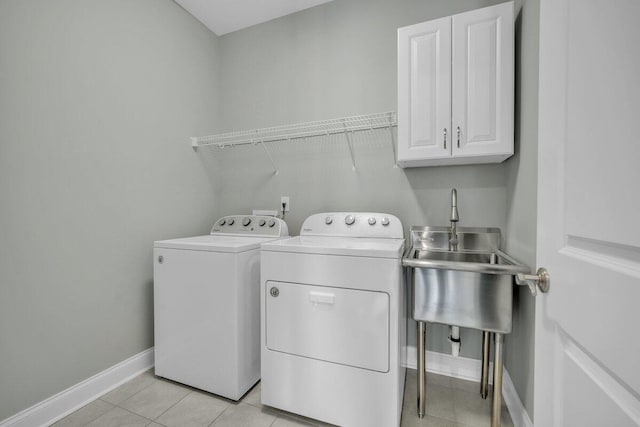 laundry area with washing machine and dryer, cabinets, light tile patterned floors, and sink