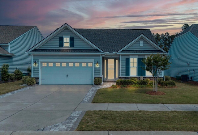 craftsman-style home with central AC, a garage, and a lawn