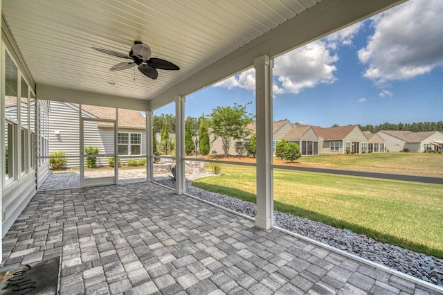 unfurnished sunroom featuring ceiling fan