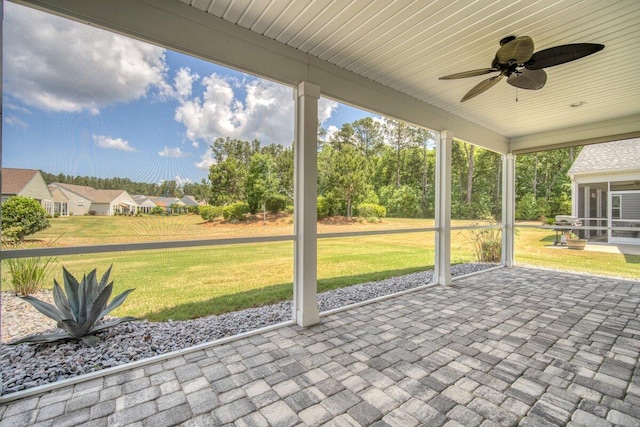 unfurnished sunroom with ceiling fan