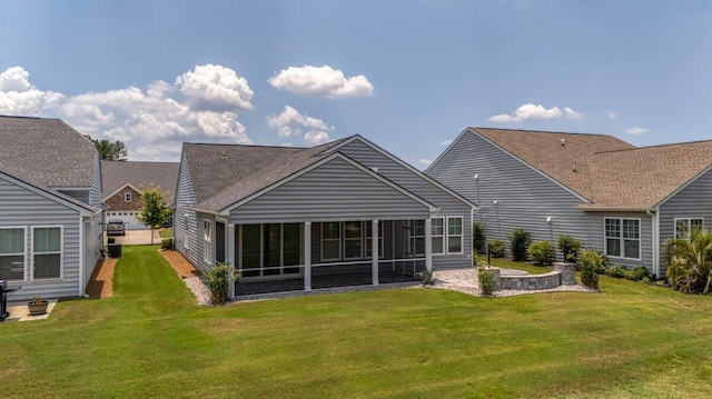 rear view of property with a lawn and a sunroom