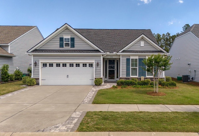 craftsman house with cooling unit, a front yard, and a garage