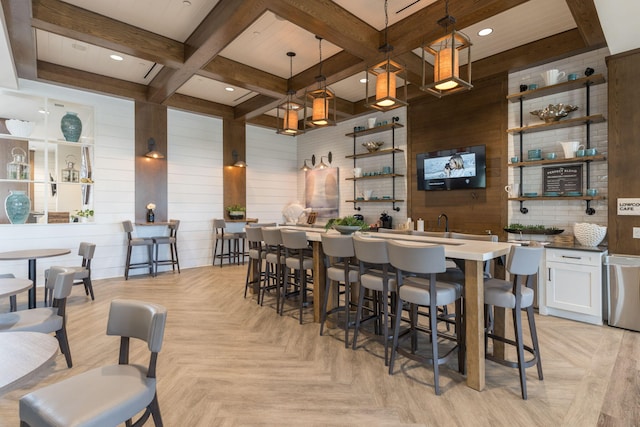 bar with decorative light fixtures, light parquet floors, wooden walls, and white cabinetry