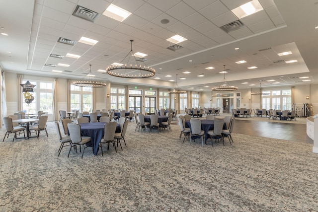 dining room with an inviting chandelier, a raised ceiling, and a paneled ceiling