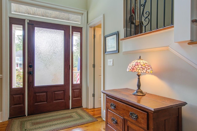 entryway with light wood finished floors and stairs