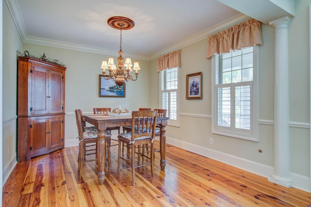 dining area with a chandelier, ornamental molding, light wood finished floors, decorative columns, and baseboards