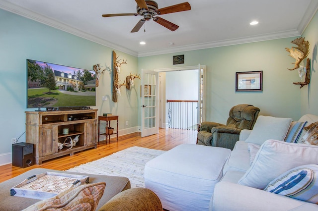 living room featuring light wood finished floors, a ceiling fan, ornamental molding, baseboards, and recessed lighting