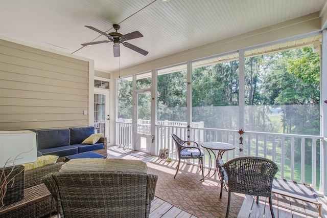 sunroom featuring ceiling fan and an outdoor living space