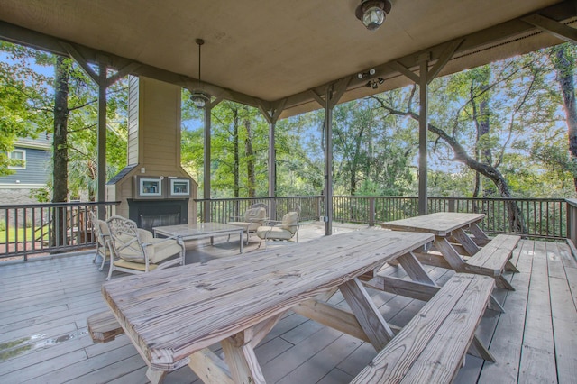deck with outdoor dining area and a fireplace