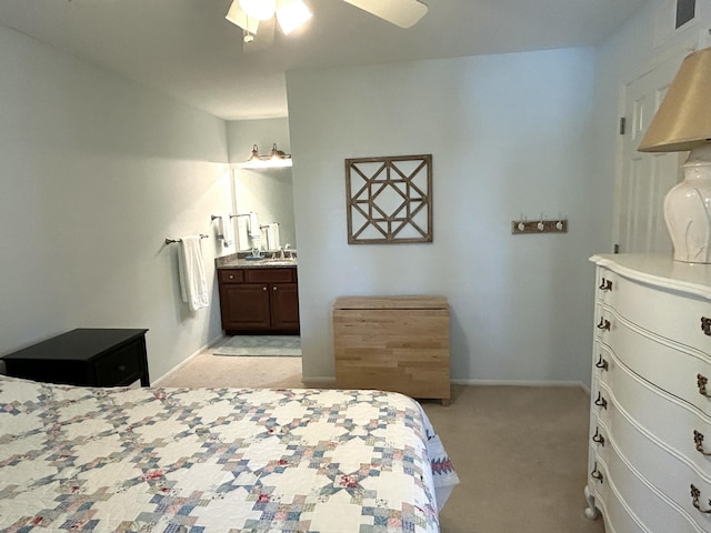 bedroom featuring light carpet, ceiling fan, and ensuite bathroom