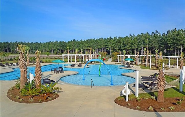 community pool featuring a patio area and a view of trees