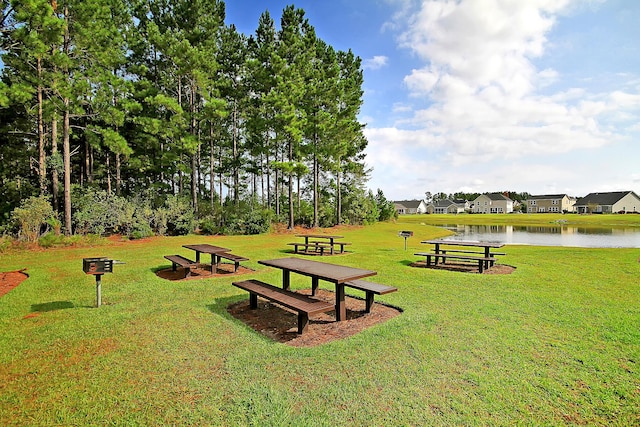 view of property's community featuring a yard, a water view, and a residential view