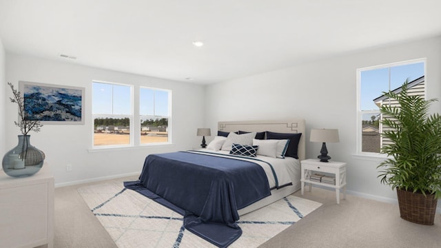 bedroom with light carpet, visible vents, and baseboards