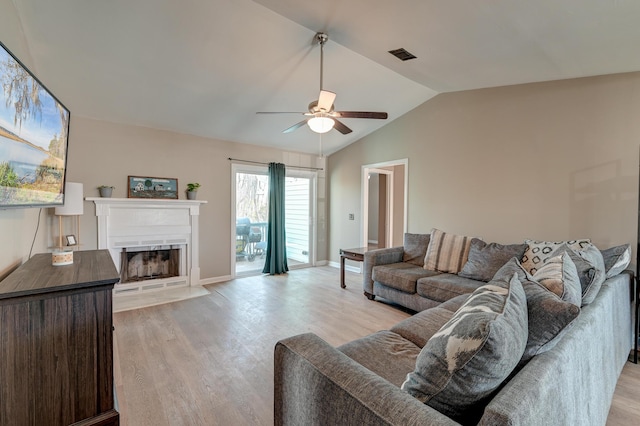 living room with vaulted ceiling, light hardwood / wood-style floors, and ceiling fan