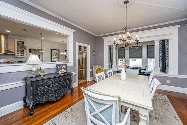 dining area featuring wood-type flooring, a notable chandelier, ornamental molding, and vaulted ceiling