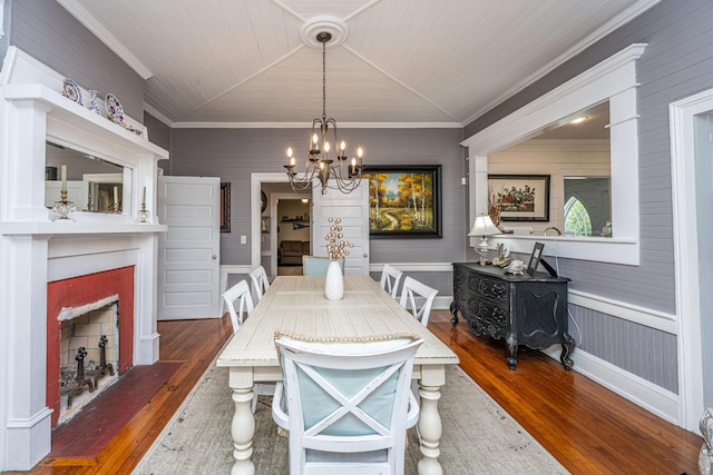 dining space featuring crown molding, vaulted ceiling, and wood finished floors