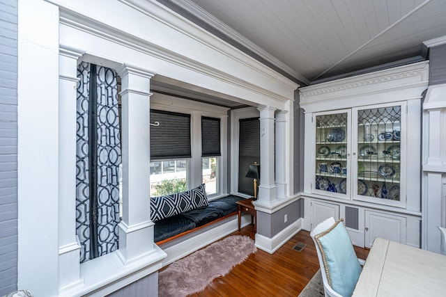 office space with visible vents, crown molding, ornate columns, wood finished floors, and vaulted ceiling
