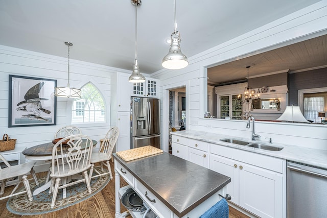 kitchen with stainless steel appliances, dark wood-type flooring, white cabinetry, a sink, and an inviting chandelier