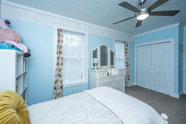 carpeted bedroom with baseboards, a closet, ornamental molding, and a ceiling fan