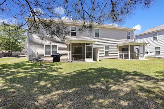 rear view of house with a sunroom, a lawn, and cooling unit
