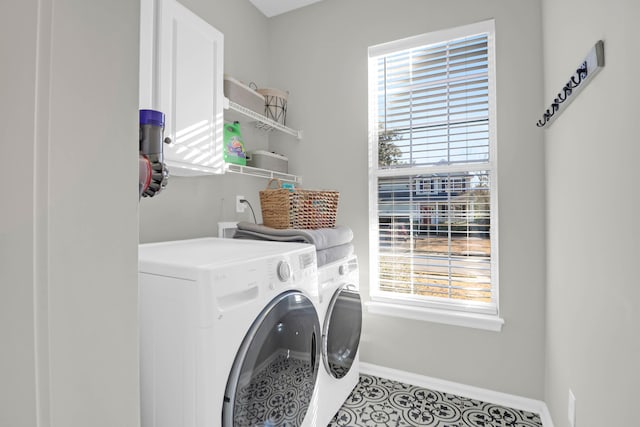 clothes washing area with cabinets, washer and dryer, and light tile patterned flooring