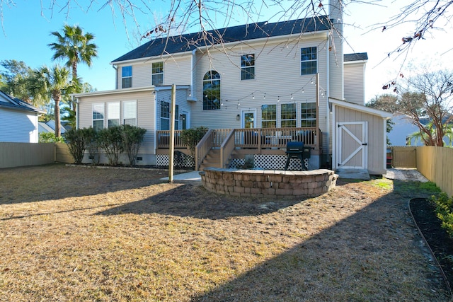 back of house featuring a wooden deck and a storage unit