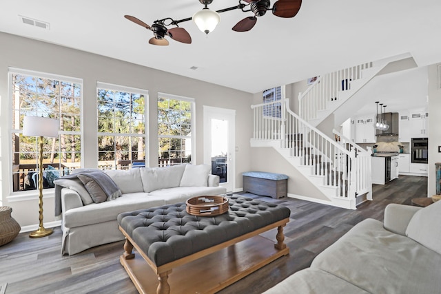 living room featuring dark wood-type flooring and ceiling fan