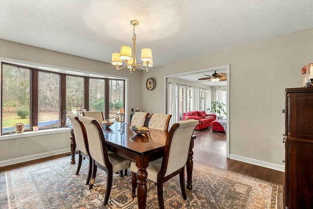 dining space featuring dark hardwood / wood-style flooring, a textured ceiling, a healthy amount of sunlight, and an inviting chandelier