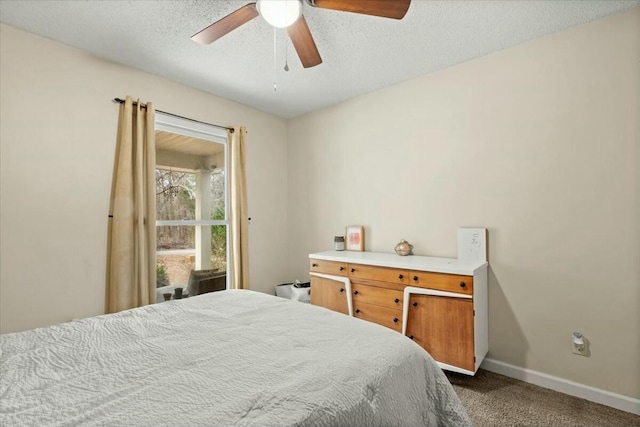 carpeted bedroom featuring ceiling fan and a textured ceiling