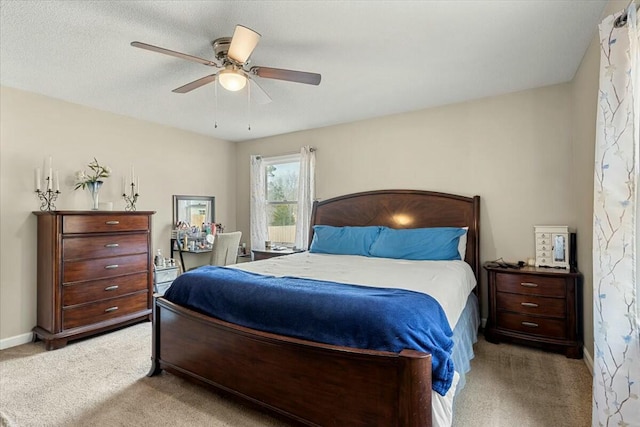 bedroom with ceiling fan, light colored carpet, and a textured ceiling