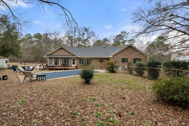 rear view of house with a wooden deck and a patio area