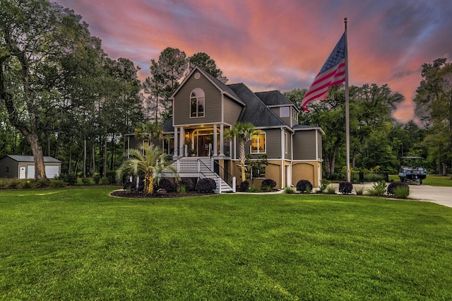 view of front of property with a garage, a lawn, and covered porch