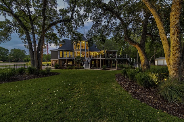 rear view of house featuring a yard and a sunroom